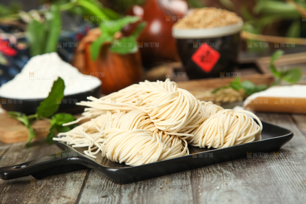 木板上放着一盘细面条