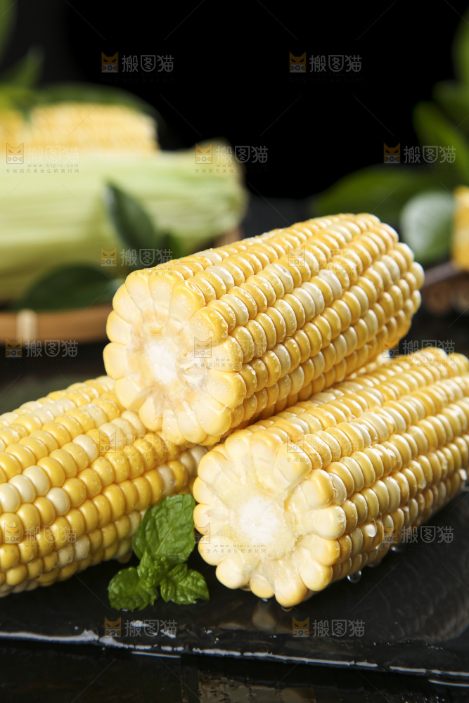黑石板上放着水果玉米