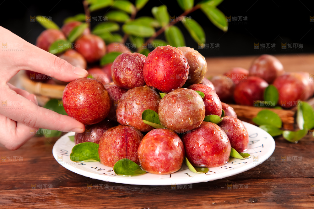 盘子里放着红肉三华李