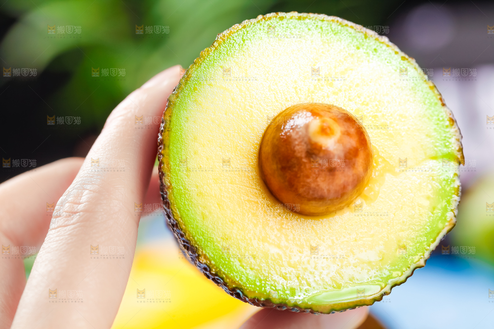 手里拿着新鲜牛油果