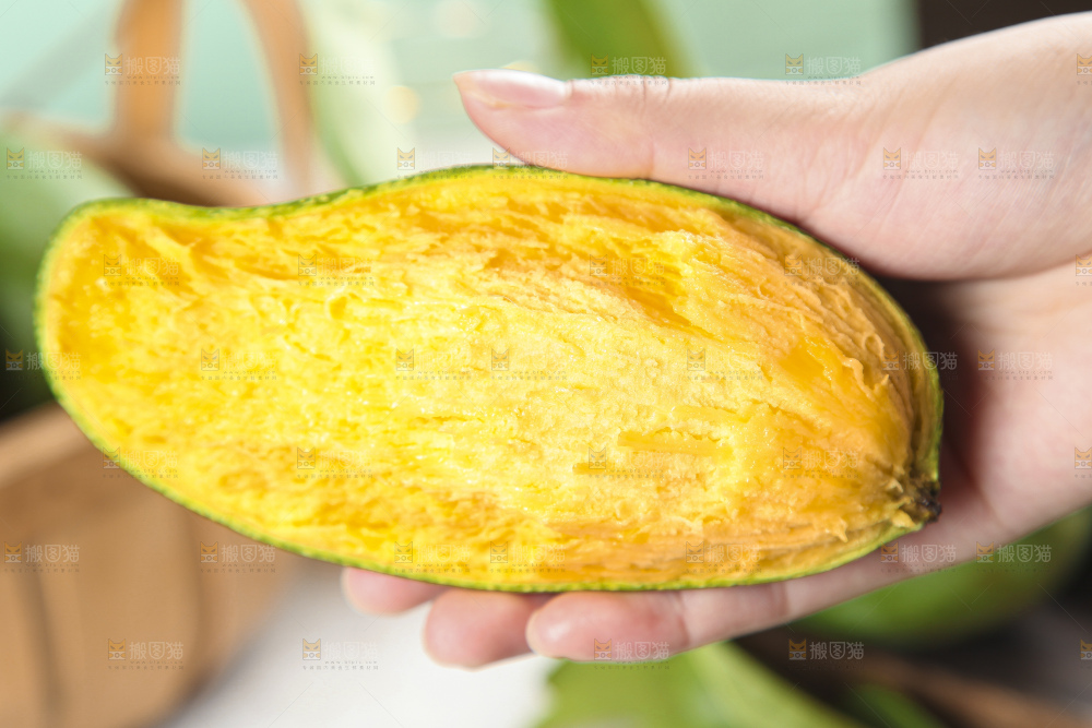 手里拿着新鲜芒果