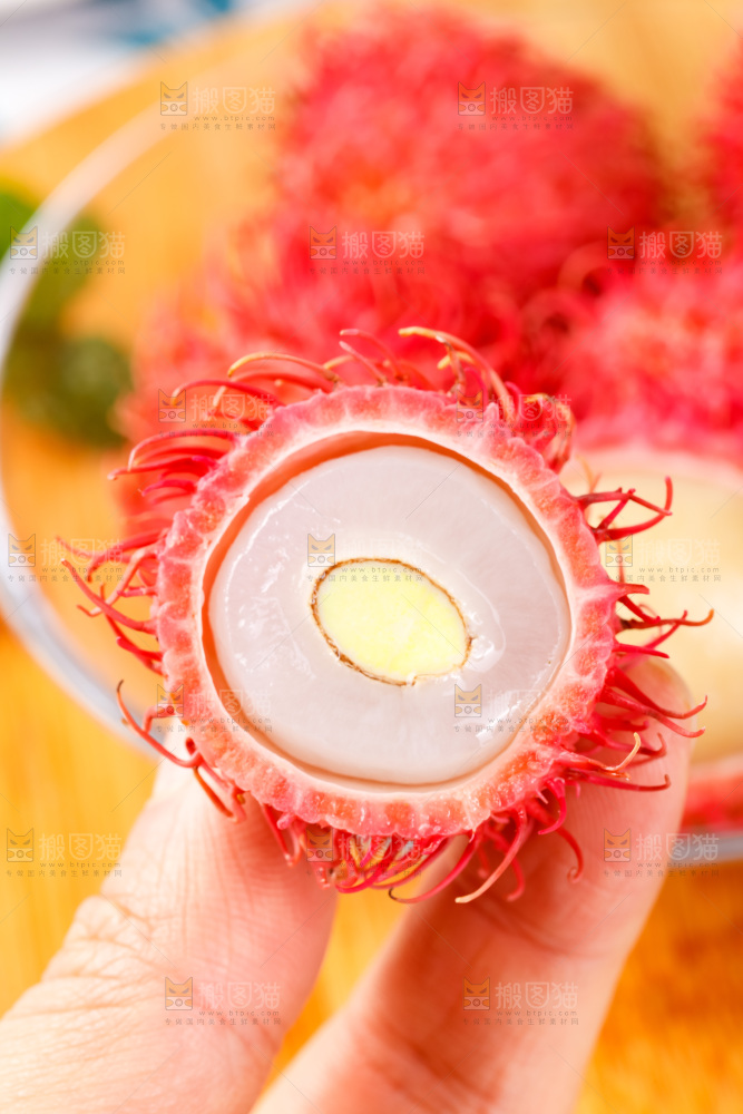 手里拿着新鲜红毛丹