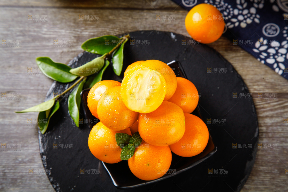 黑石板上放着新鲜金桔