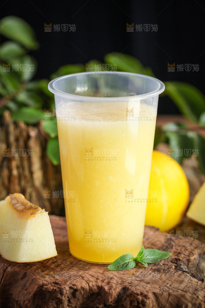 木底上放着一杯黄金蜜瓜果汁