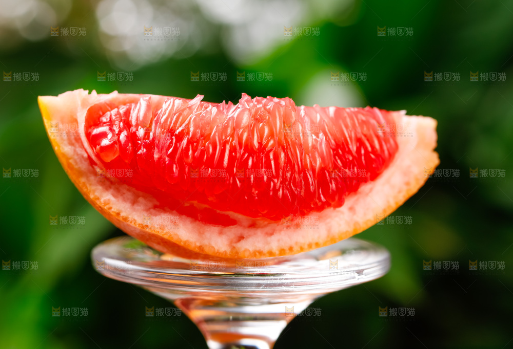 玻璃杯上放着红肉西柚