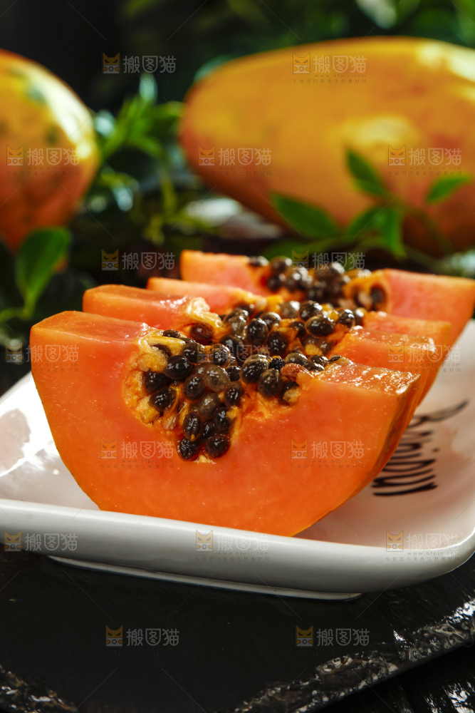 黑底上放着新鲜的海南红心木瓜