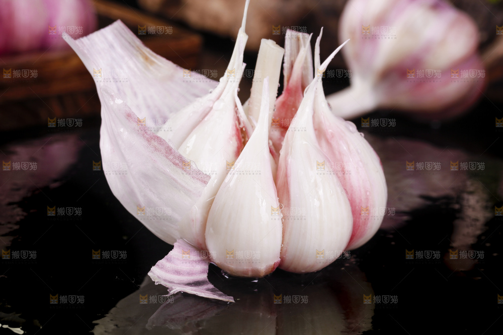 黑底上放着新鲜紫皮多瓣蒜
