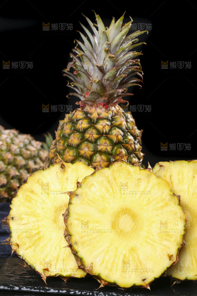 黑石板上放着切开的新鲜凤梨
