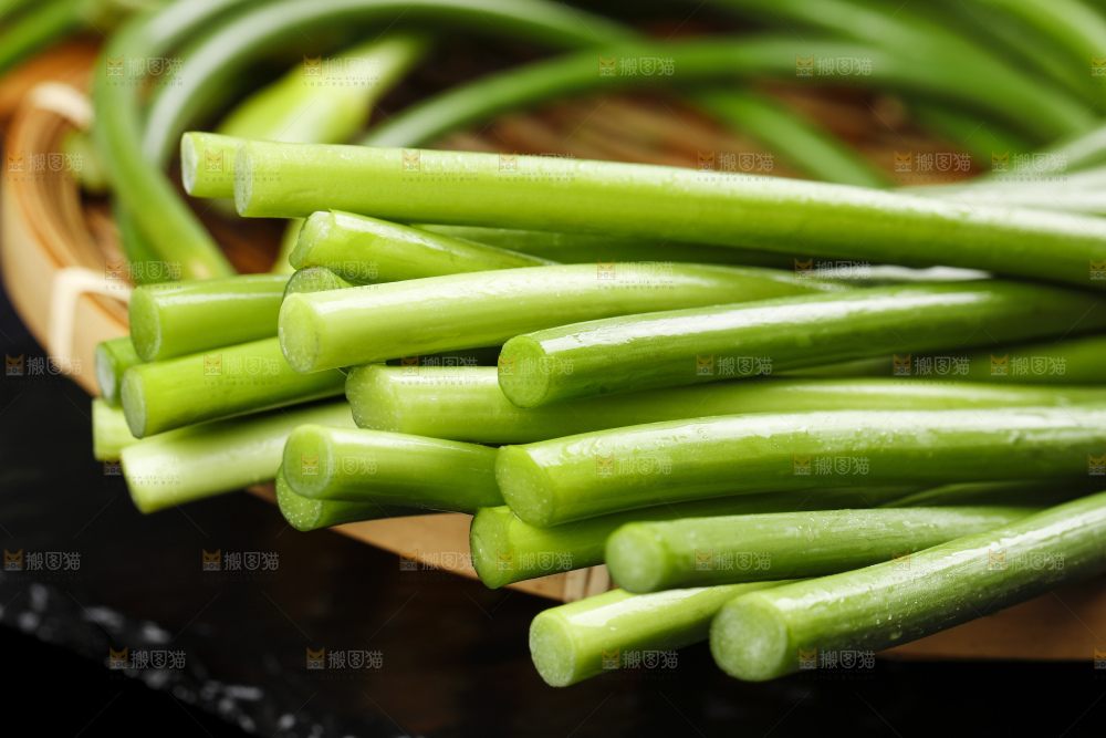 黑石板上放着一把蒜苔