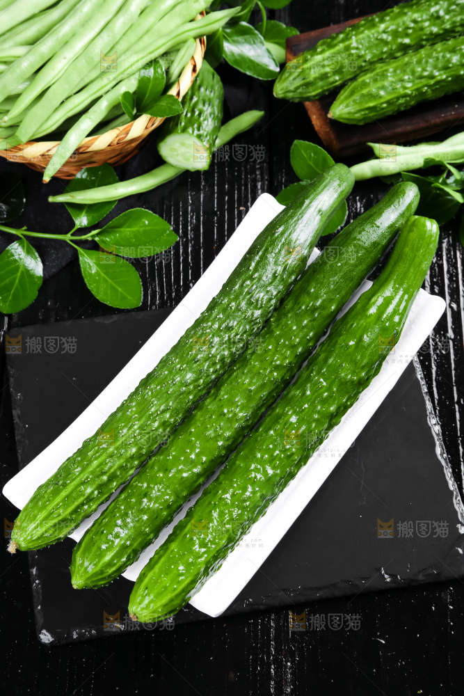 一盘新鲜土黄瓜放在黑底上
