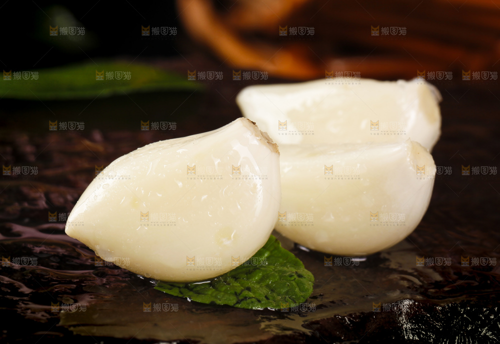 黑底上放着剥皮的新鲜紫皮大蒜
