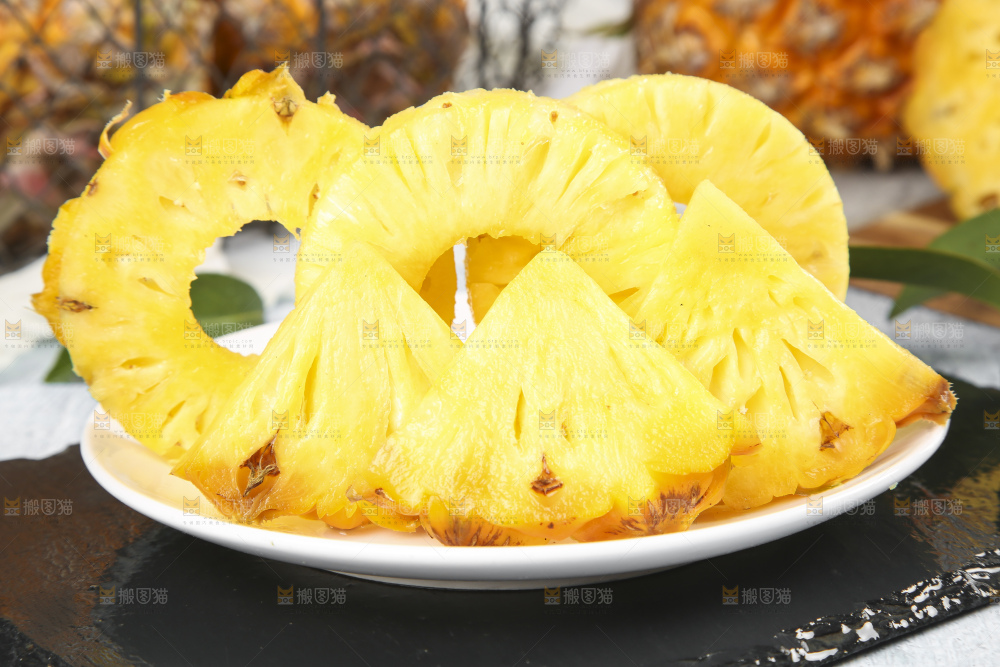 黑石板上放着一盘新鲜菠萝果肉