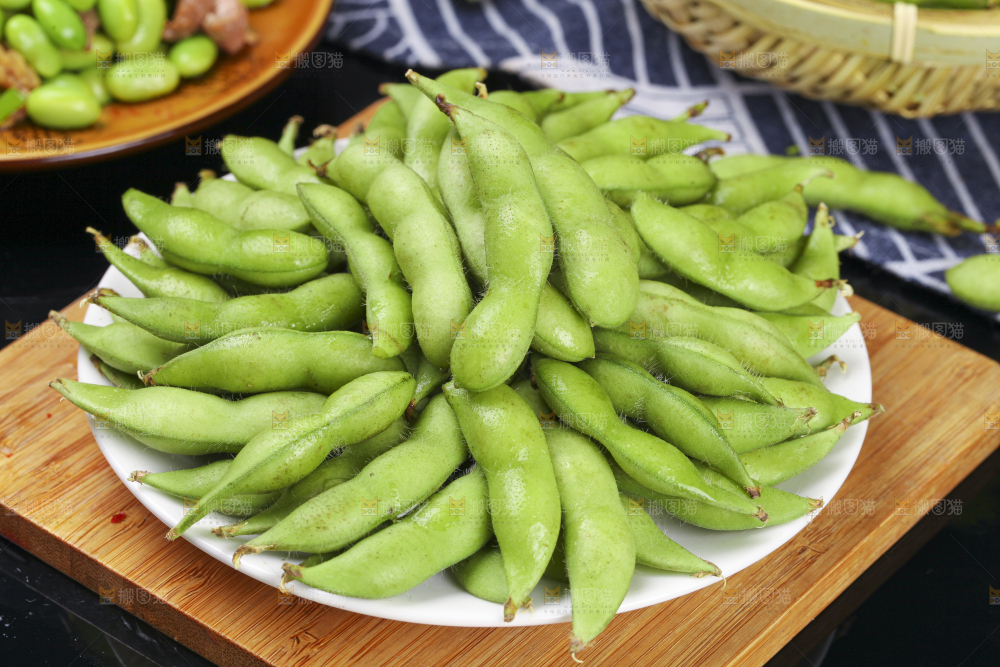 木板上放着一盘新鲜毛豆