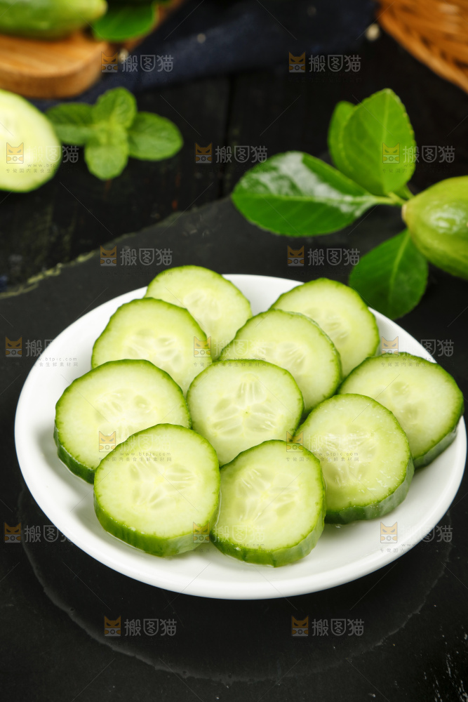 黑底上放着一盘水果黄瓜片