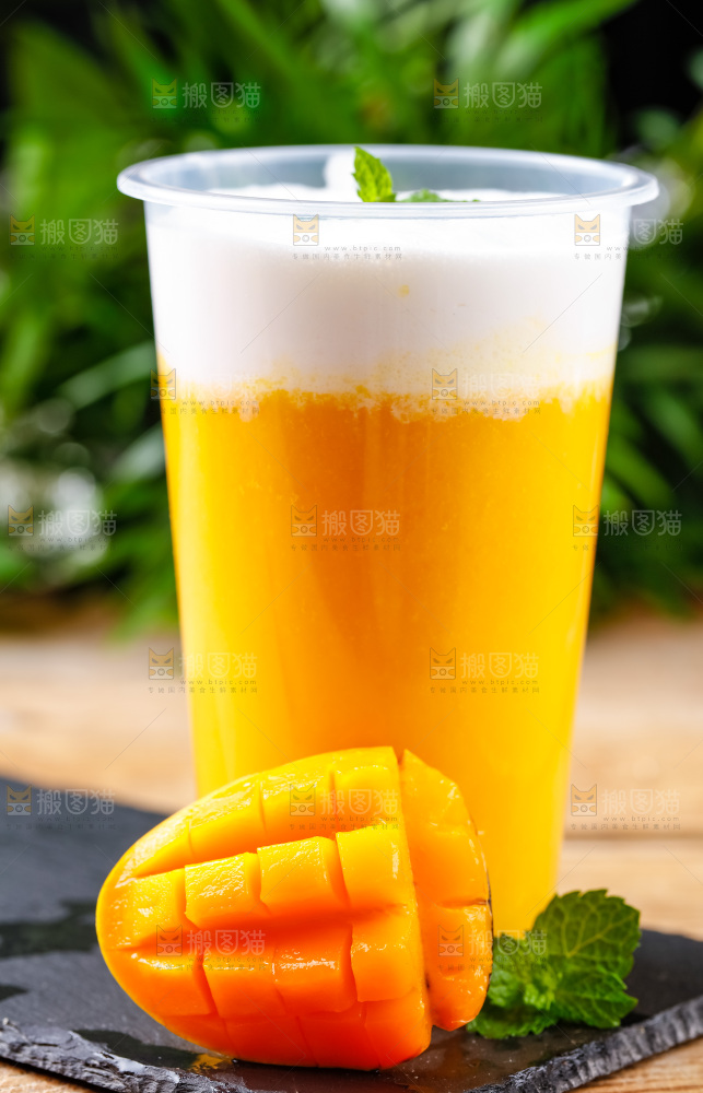 黑石板上放着一杯芒果果汁