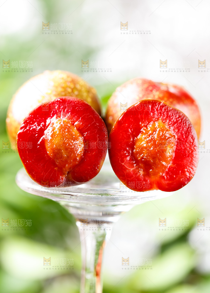 玻璃杯上放着红心李