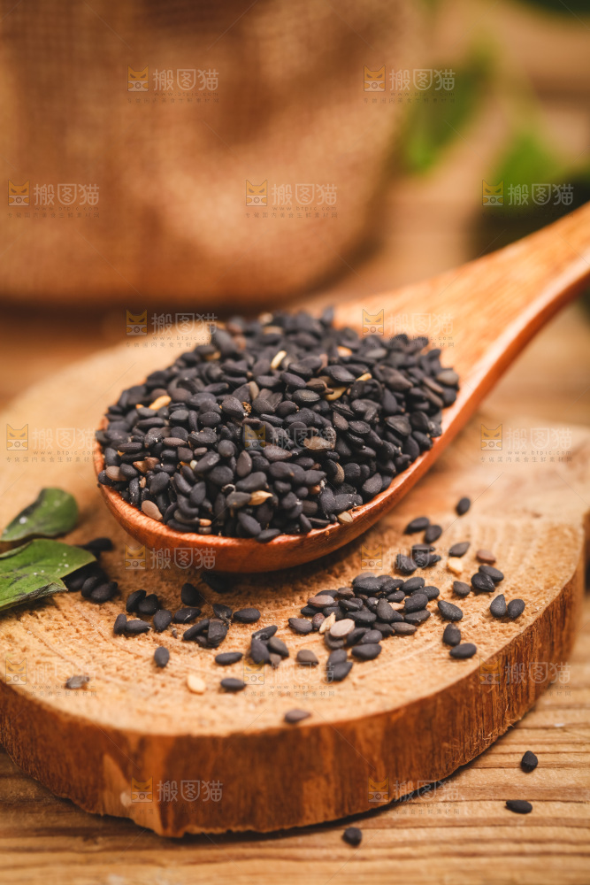 木板上放着一勺黑芝麻