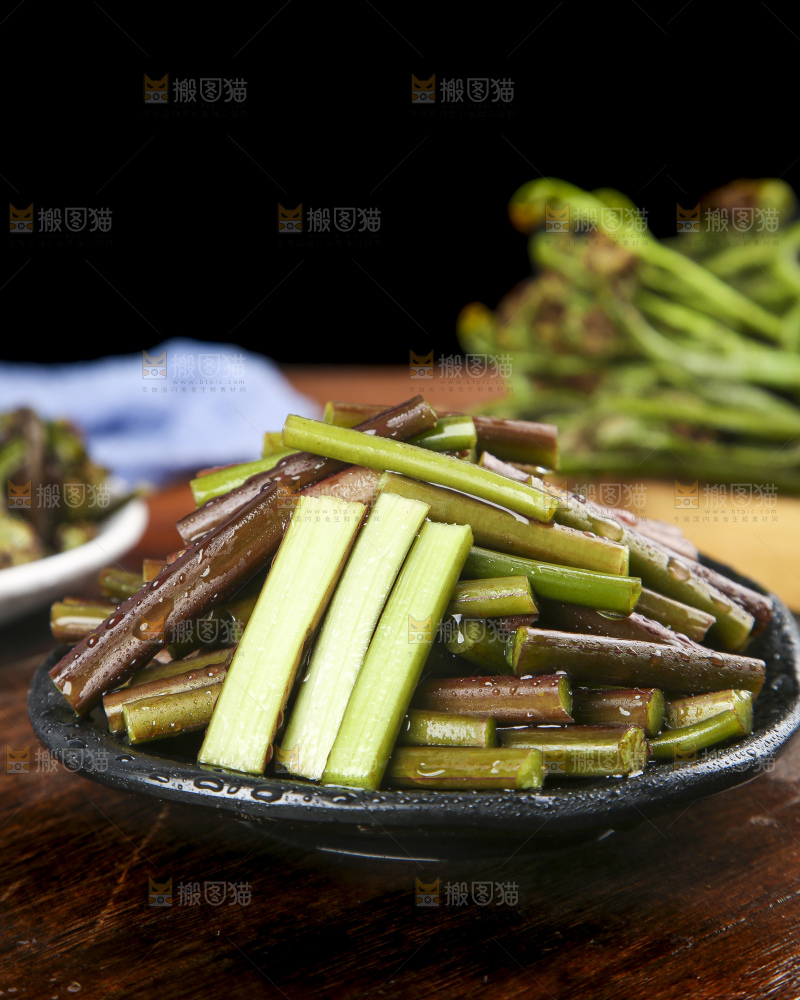一盘蕨菜摆放在木板上