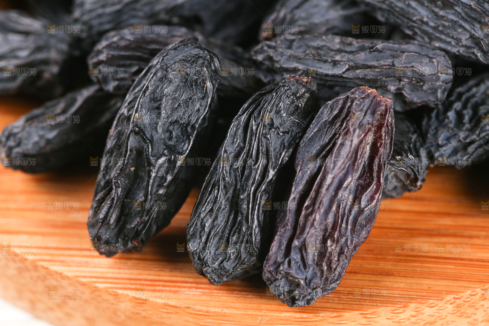 木板上放着一堆黑加仑葡萄干