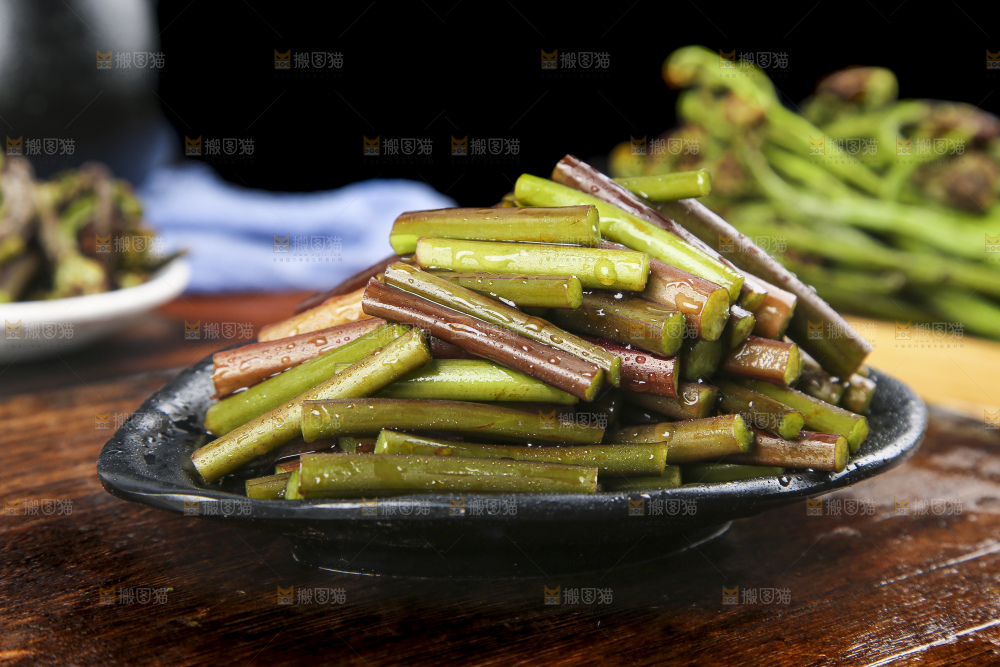 一盘蕨菜摆放在木板上