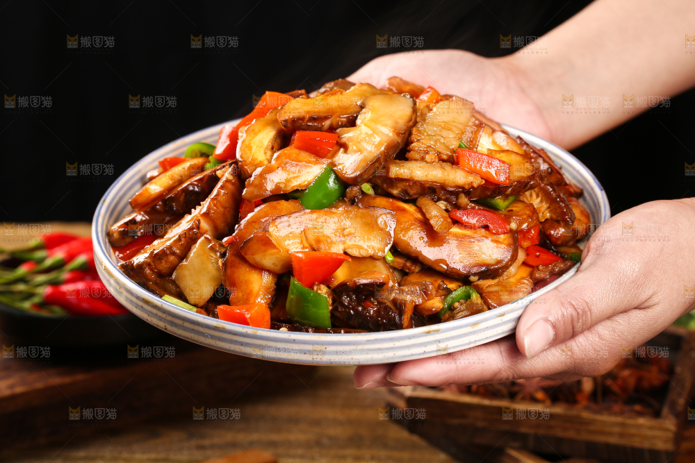 手里端着一盘花菇炒肉
