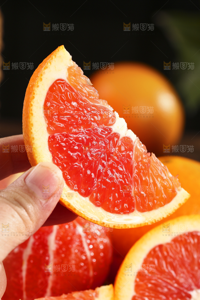 手里拿着一块血橙