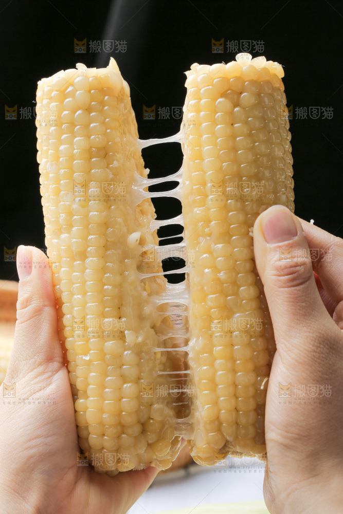 手里拿着白糯玉米棒