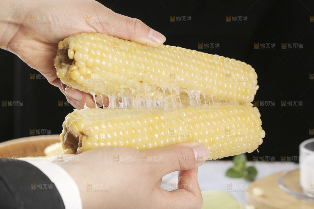 手里拿着白糯玉米
