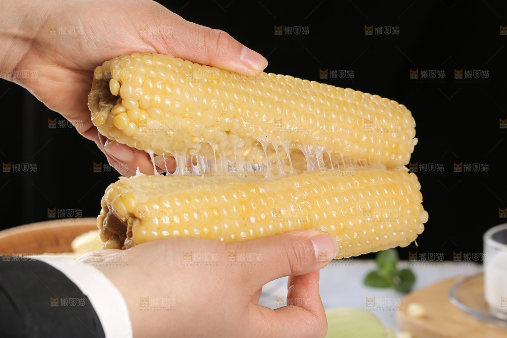 手里拿着白糯玉米棒