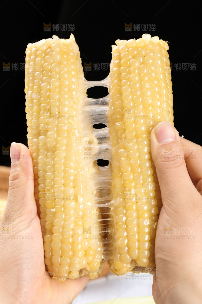 手里拿着白糯玉米棒