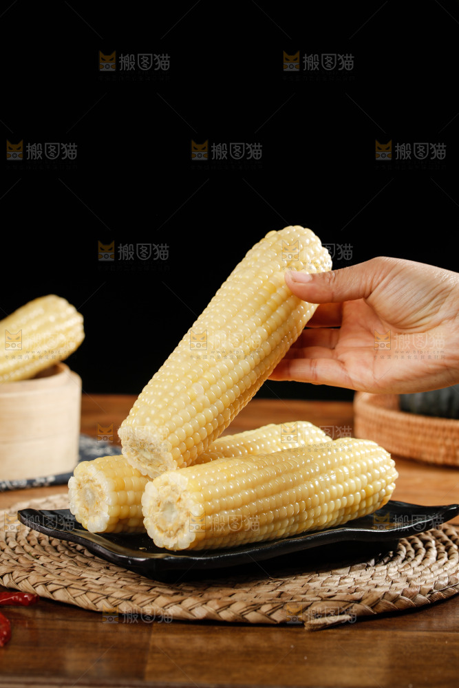 手里拿着白糯玉米棒