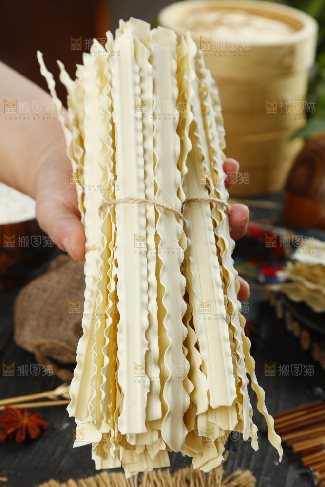 手上拿着手工刀削面