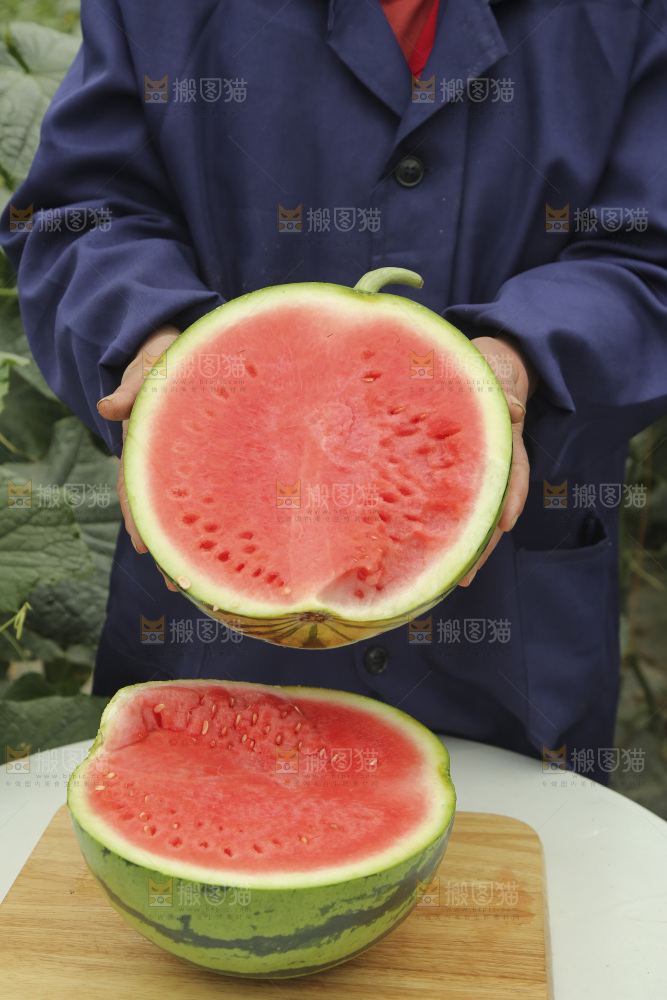 手里拿着半边切面的红心西瓜