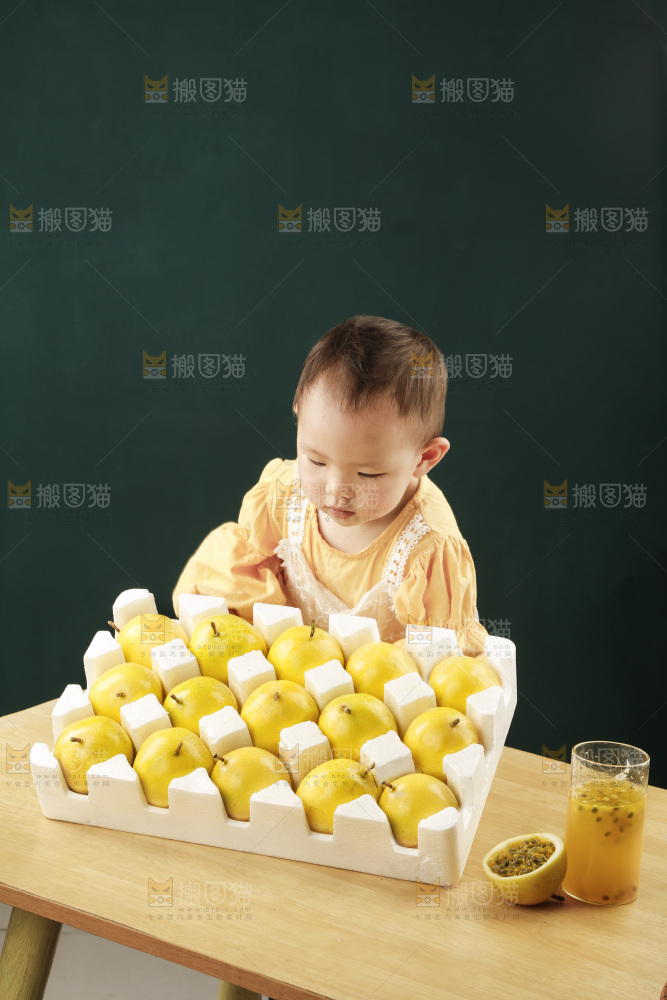 小孩面前桌子摆放着一箱黄金百香果