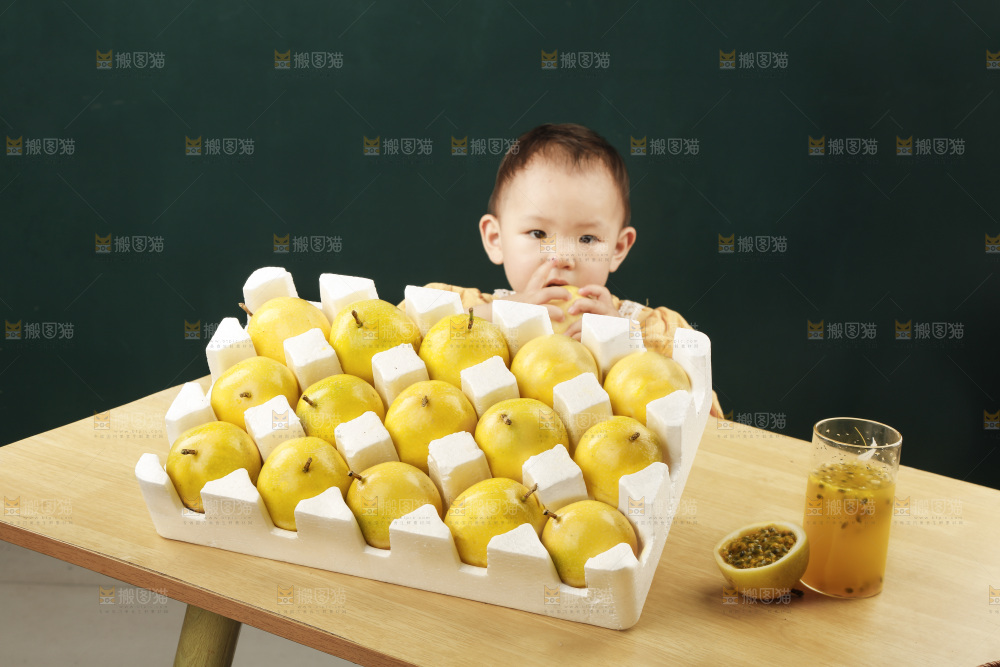 小孩面前桌子摆放着一箱黄金百香果