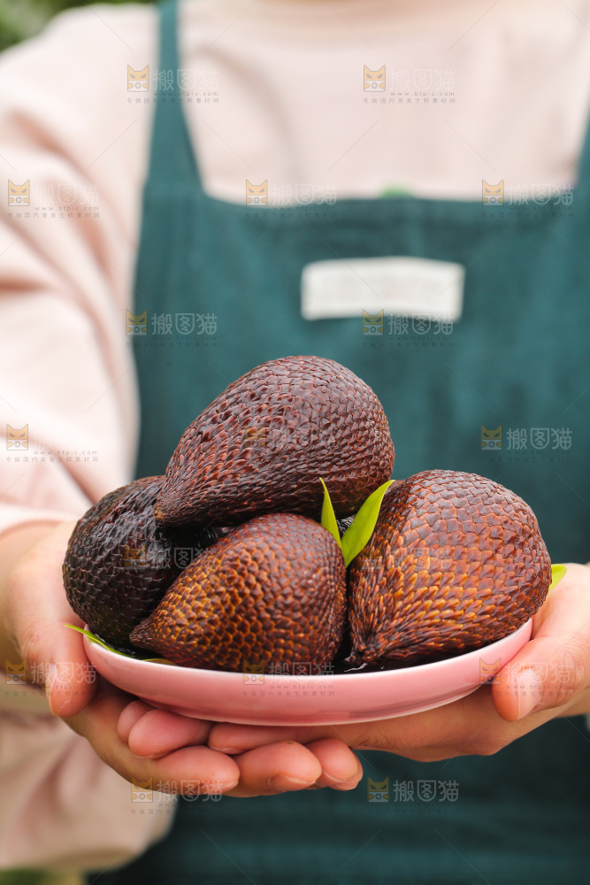 手里端着一盘蛇皮果