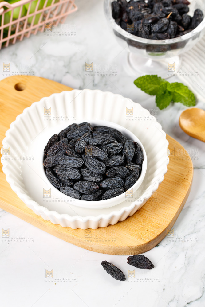 木板上放着一盘黑加仑葡萄干