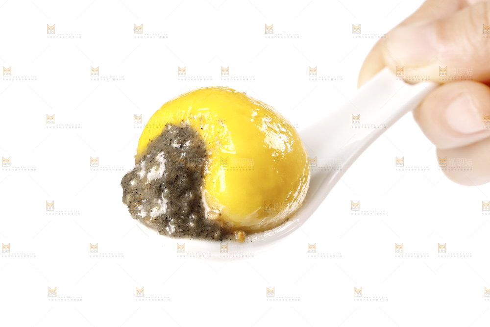 勺子上舀着黑芝麻馅汤圆