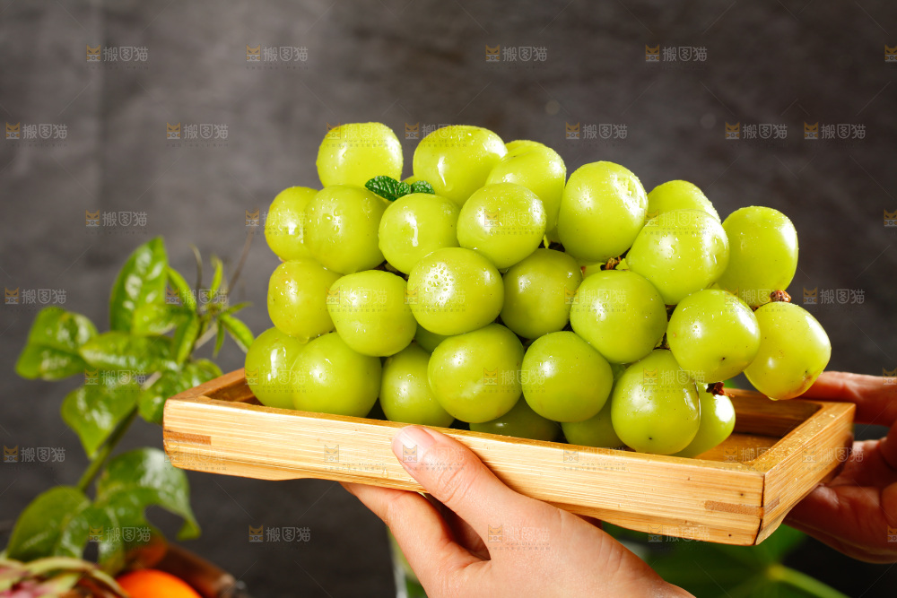 手里端着一盘阳光玫瑰葡萄