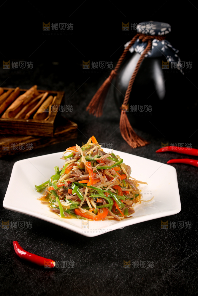 黑底上放着一盘辣椒炒鸡肉丝