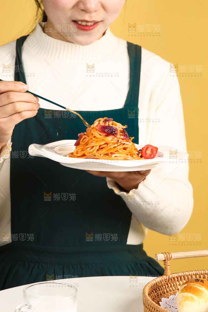 手里端着一盘黑胡椒意大利面