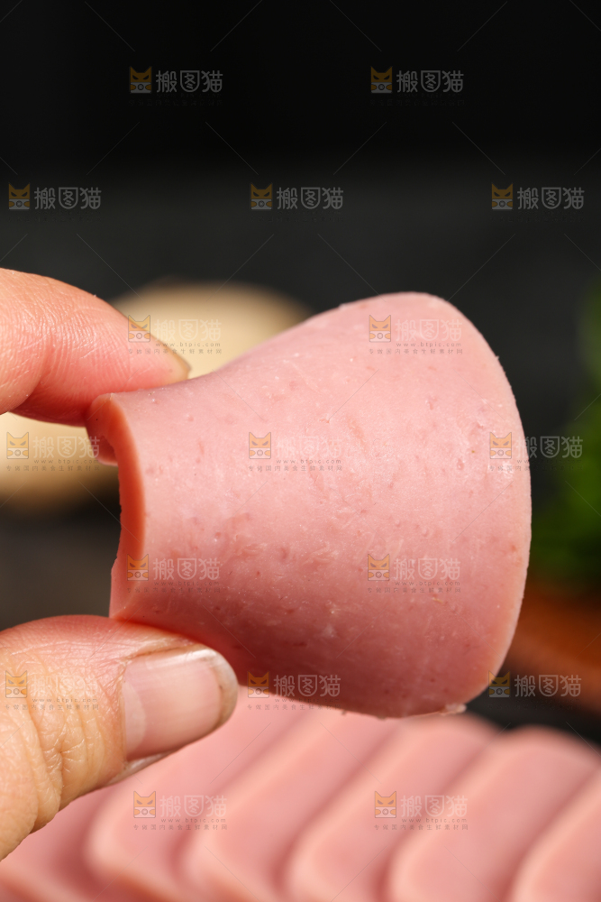 手里拿着切片的午餐肉