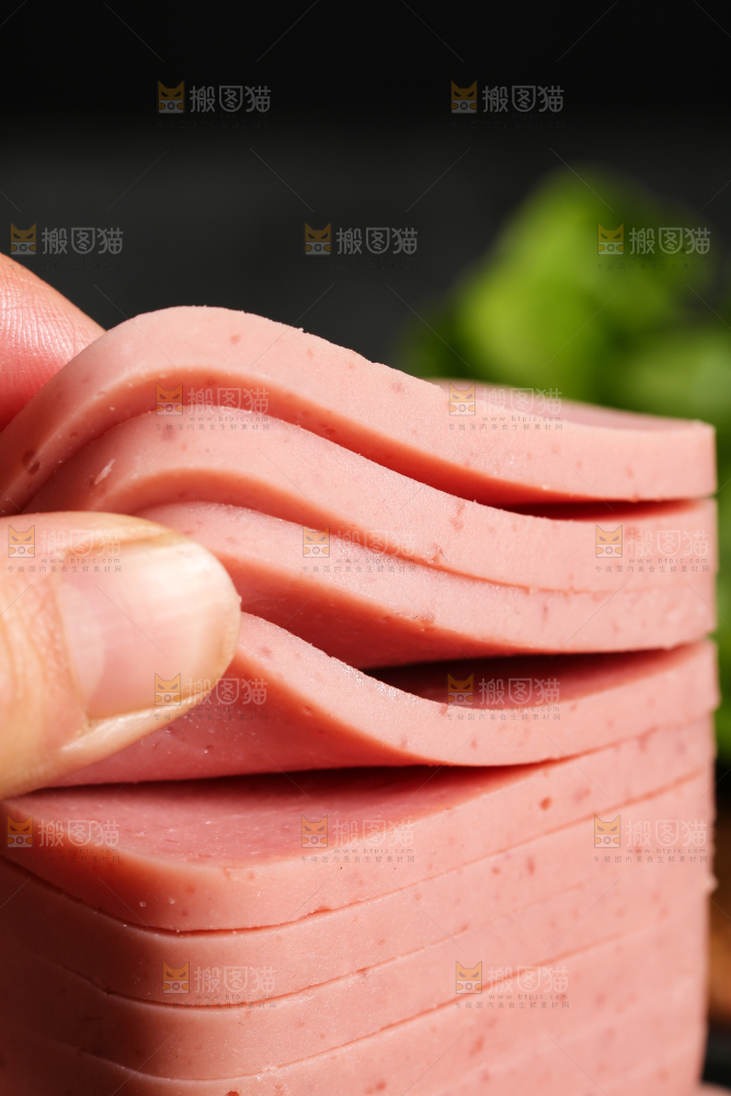 手里拿着切片的午餐肉