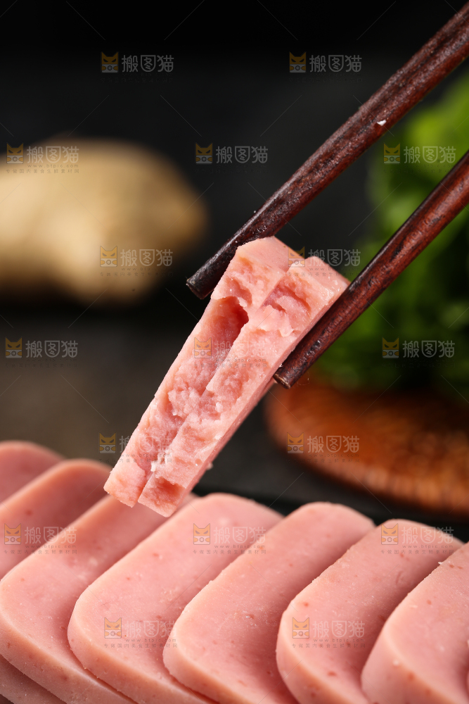 筷子上夹着切块的午餐肉