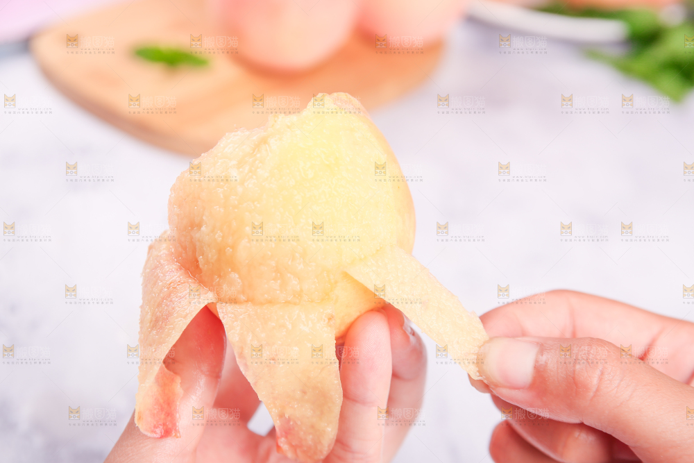 手拿着剥了皮阳山水蜜桃