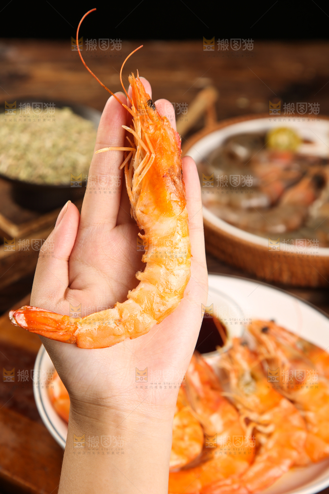 手里拿着白灼大虾