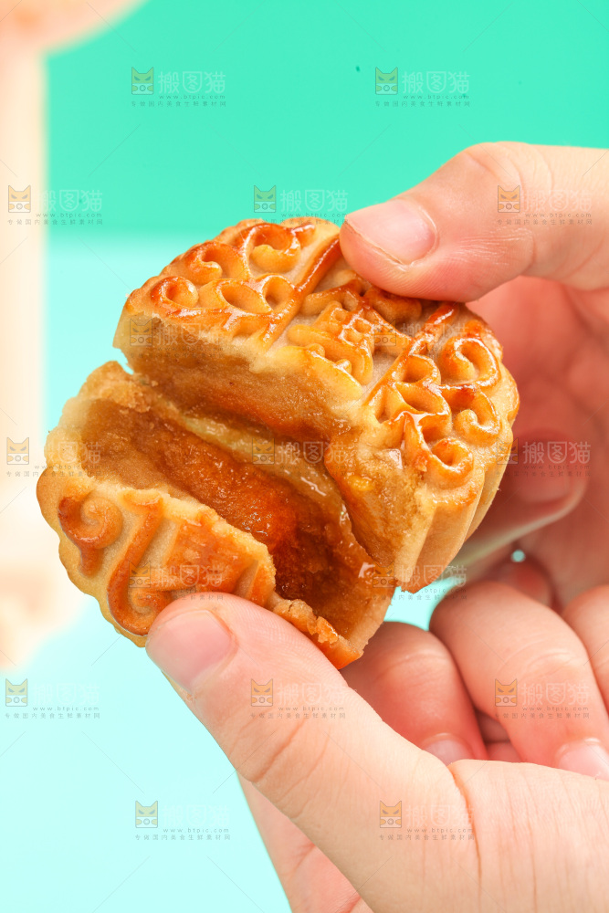 手拿着掰开的蛋黄月饼