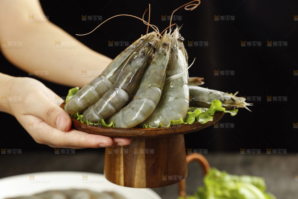 手上端着一盘对虾