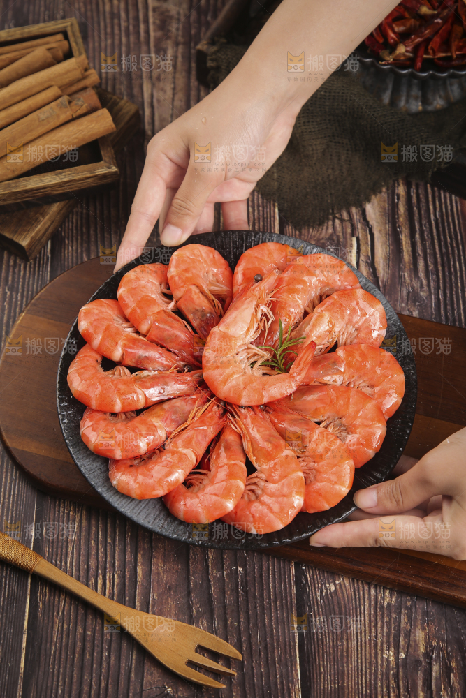 手上端着一盘清蒸虾