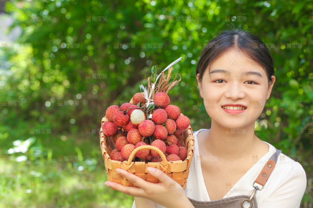 女人手上拿着一筐无核荔枝